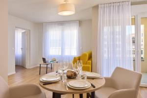 a dining room and living room with a table and chairs at Quality Aparthotel Rouen in Rouen