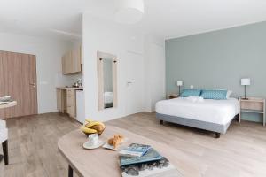 a bedroom with a bed and a table with bananas on it at Quality Aparthotel Quiberon in Quiberon +37 photos