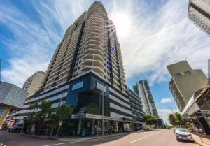 a tall building on a city street with a blue sky at Darwin Harbour Sunset Views in Darwin