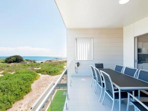 a dining room with a table and chairs and the ocean at 41 Ocean in Anna Bay