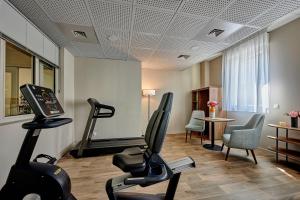 a fitness room with exercise equipment and a table at Quality Aparthotel Cherbourg in Cherbourg en Cotentin
