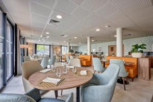 a dining room with a table and chairs at Quality Aparthotel Cherbourg in Cherbourg en Cotentin