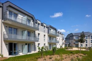 an apartment building with balconies and a yard at Quality Aparthotel Cholet in Cholet