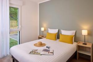 a bedroom with a bed with a hat on it at Quality Aparthotel Ploërmel in Ploërmel