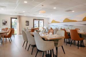 a dining room with tables and chairs at Quality Aparthotel Ploërmel in Ploërmel