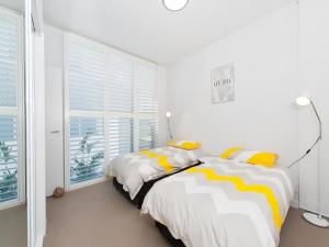 a bedroom with two beds with yellow and white stripes at 41 Ocean in Anna Bay