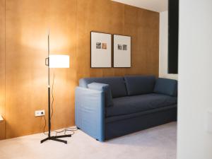 a living room with a blue couch and a lamp at Círculo Condal in Barcelona