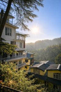 a group of buildings with the sun in the background at Kaisha Himalayan View in Shimla