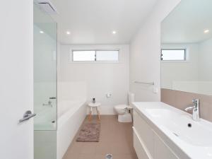 a white bathroom with a sink and a toilet at 41 Ocean in Anna Bay +13 photos