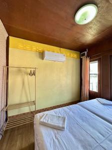 a bedroom with a bed and a window at Thai Style House - Yao Noi in Ko Yao Noi