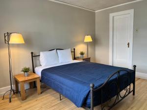 a bedroom with a bed with a blue comforter and two lamps at Grand Union Hotel in Coleman