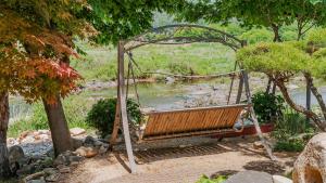 a swing in a garden near a pond at Gapyeong ebenzer Pension in Gapyeong