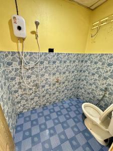a bathroom with a toilet and a tiled wall at Thai Style House - Yao Noi in Ko Yao Noi