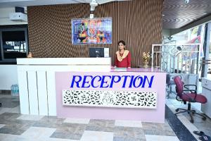 a woman standing behind a reception desk in an office at SRIPADAVALLABHANIVAS2 pithapuram in Pithāpuram