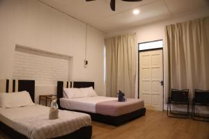 a bedroom with two beds and a window and a door at Penyu Bari in Setiu +15 photos