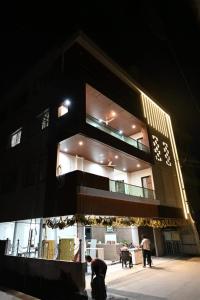 a building with people standing outside of it at night at SRIPADAVALLABHANIVAS2 pithapuram in Pithāpuram