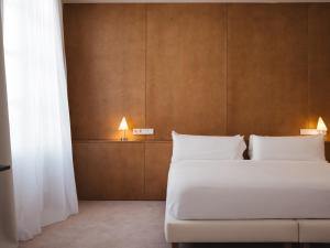 a bedroom with a large bed with white pillows at Círculo Condal in Barcelona