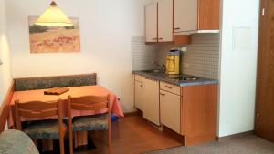 a small kitchen with a table and a sink and a counter at Landhaus Aggenstein in Haldensee