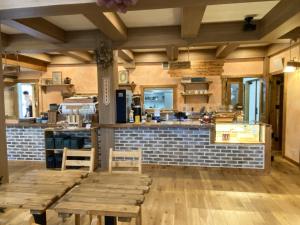 a restaurant with two wooden tables and a bar at Resort Door in Yamanakako