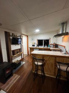 a kitchen with a stove and some chairs in a room at Departamento la espiga in Chaitén