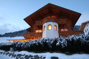 a log cabin in the snow with the lights on at Alpenparadies Grösser in Heinfels