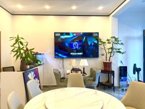 a room with a tv on a wall with a table and chairs at Tam Coc Sunny House in Vũ Lâm