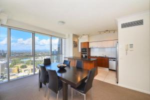 a kitchen and dining room with a table and chairs at Deluxe Chevron Renaissance in Gold Coast