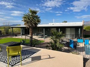 a house with a palm tree and a yellow chair at The Tortolita House in Tucson