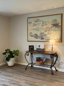a table with a lamp and a picture on the wall at The Tortolita House in Tucson