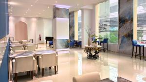 a waiting room with tables and chairs in a building at Paul and Pam Hotel Bangkok in Bang Kapi