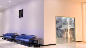 a waiting room with blue chairs and a glass door at Paul and Pam Hotel Bangkok in Bang Kapi