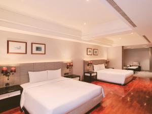 a hotel room with two beds and a desk at Rhyme&Time Hotel in Kaohsiung