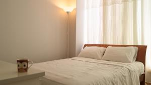 a bedroom with a bed with a lamp and a window at Sokcho Maru Pension in Sokcho