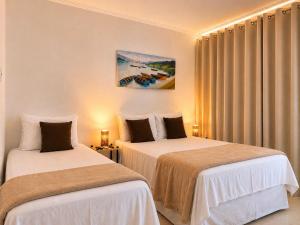 two beds in a hotel room with curtains at Pousada Bella Boipeba in Ilha de Boipeba +66 photos