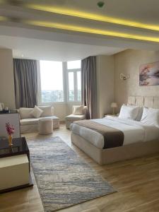 a bedroom with a large bed and a living room at Wonders Pyramids Hotel in Cairo