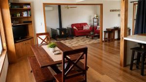 a living room with a table and a red couch at Coastal Cottage in Saint Leonards