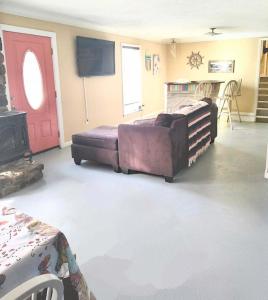 a living room with a couch and a red door at The Little House at EVOO in Cookeville
