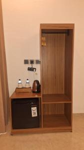 a room with a wooden cabinet and a microwave at Jou Trekking Guesthouse in Senaru