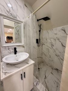 a white bathroom with a sink and a mirror at Oceanview Suites in Saint Georgeʼs +123 photos