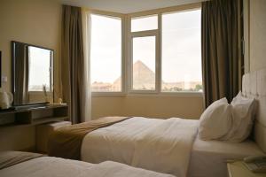 a hotel room with a bed and two windows at Wonders Pyramids Hotel in Cairo