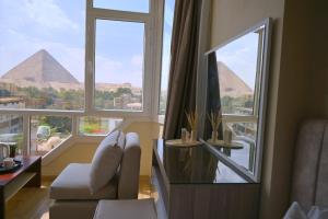 a living room with a view of the pyramids at Wonders Pyramids Hotel in Cairo +82 photos