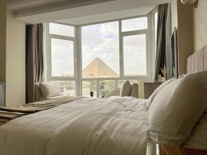 a bedroom with a large bed and a pyramid window at Wonders Pyramids Hotel in Cairo