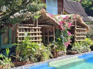 a house with a swimming pool and flowers at Bleu Verde, The Self Healing Hotel & Retreat in Gili Trawangan