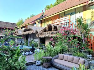 a garden with a couch in front of a building at Bleu Verde, The Self Healing Hotel & Retreat in Gili Trawangan