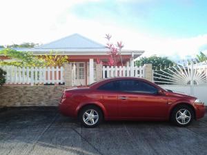 a red car parked in front of a house at Villa Le Balisier in Le Lamentin