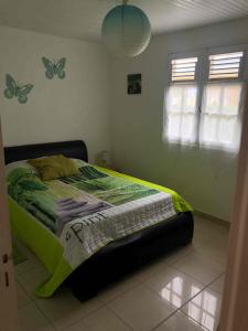 a bedroom with a bed with butterflies on the wall at Villa Le Balisier in Le Lamentin