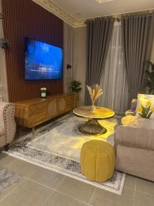a living room with a table and a tv at Yueeda Homestay in Jertih