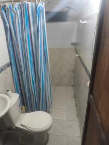 a bathroom with a toilet and a shower curtain at Posada El Encanto in Nuquí +8 photos
