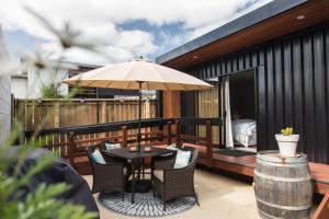 a patio with a table and an umbrella at BeachBox Boutique Accommodation in Coopers Beach