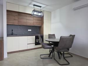 a kitchen with a table and chairs in a room at Amd Ville Apartments in Dobra Voda